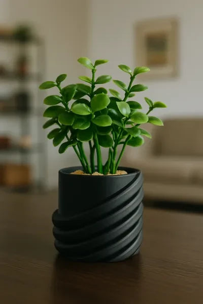 My Store 2 artificial succulent with lush green leaves in a modern matte black spiral-ribbed ceramic pot on a table.